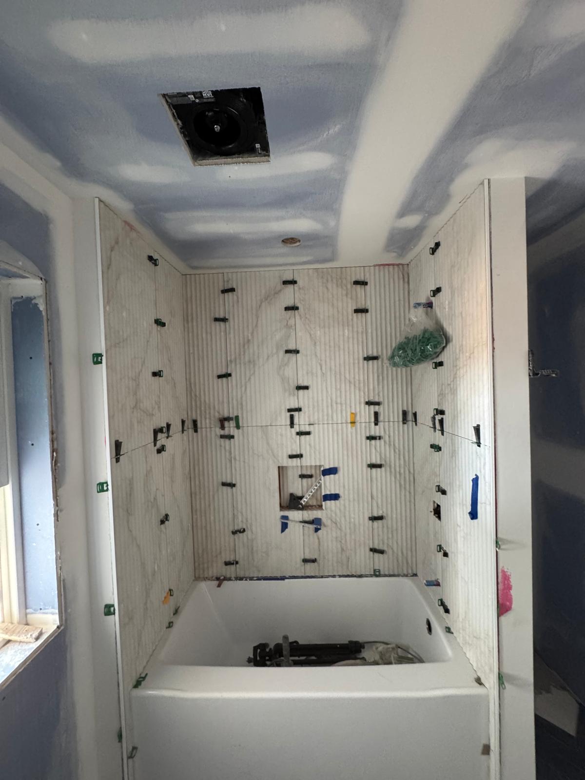 Luxury tub & shower remodel — 24" × 48" porcelain wall tile, precision waterproofing, recessed niche, and premium brass fixtures for a clean, spa-inspired finish. — 1