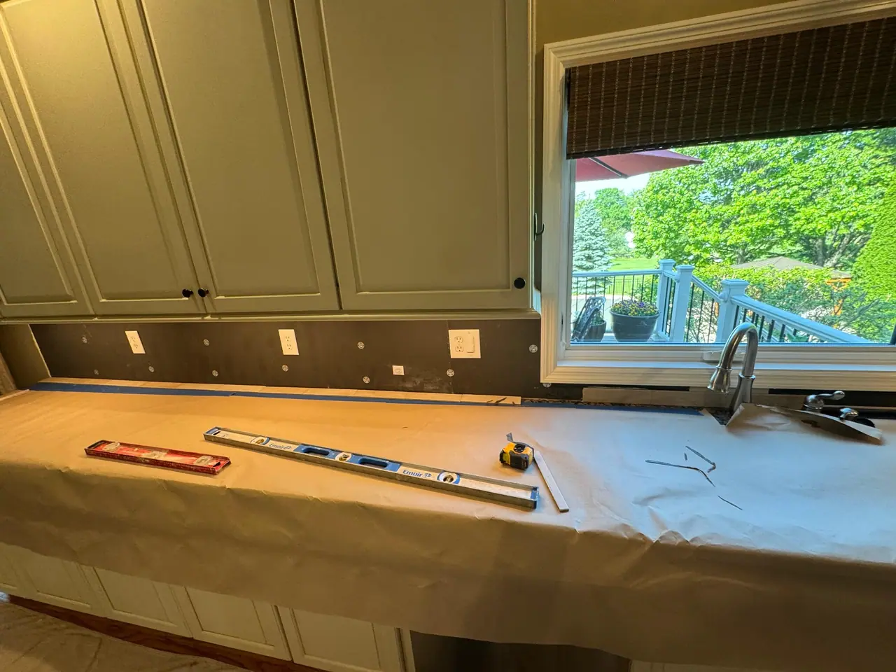 Full kitchen backsplash installation — natural stone subway tile with granite countertops and marble island. — 1
