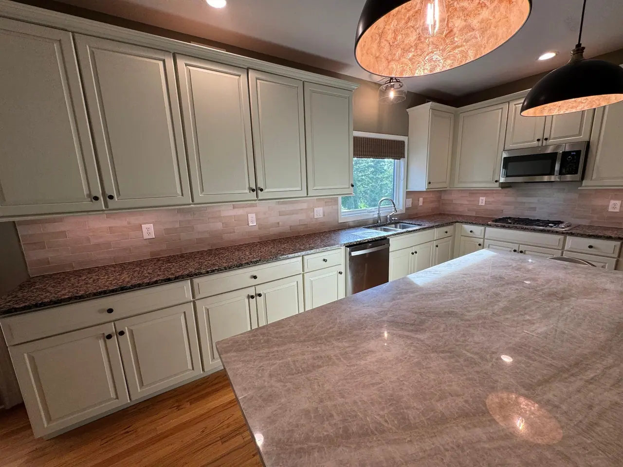 Full kitchen backsplash installation — natural stone subway tile with granite countertops and marble island. — 3