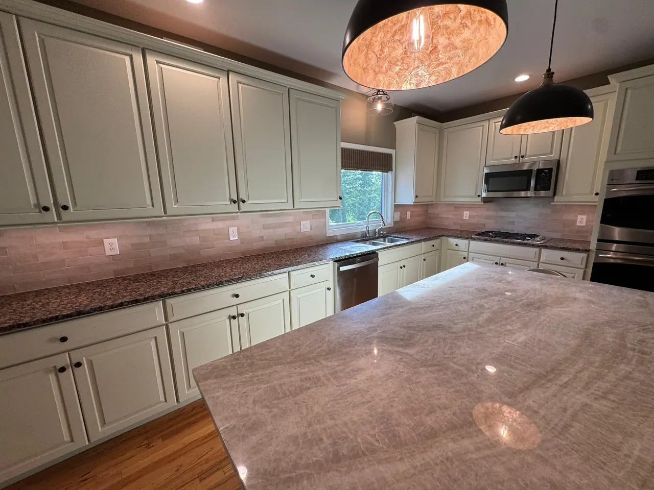 Full kitchen backsplash installation — natural stone subway tile with granite countertops and marble island. — 4