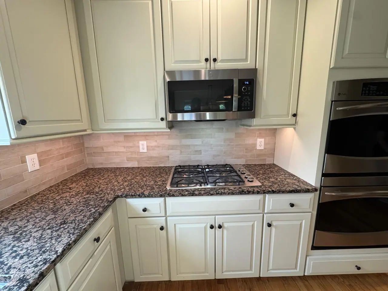 Full kitchen backsplash installation — natural stone subway tile with granite countertops and marble island. — 5