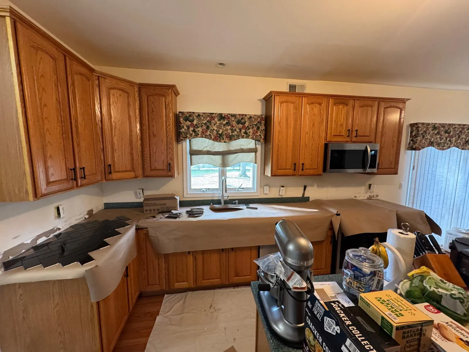 Full kitchen backsplash transformation — glossy black ceramic subway tile in herringbone pattern with crisp grout lines. — 1