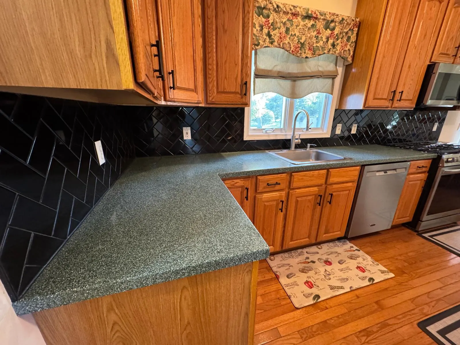 Full kitchen backsplash transformation — glossy black ceramic subway tile in herringbone pattern with crisp grout lines. — 5