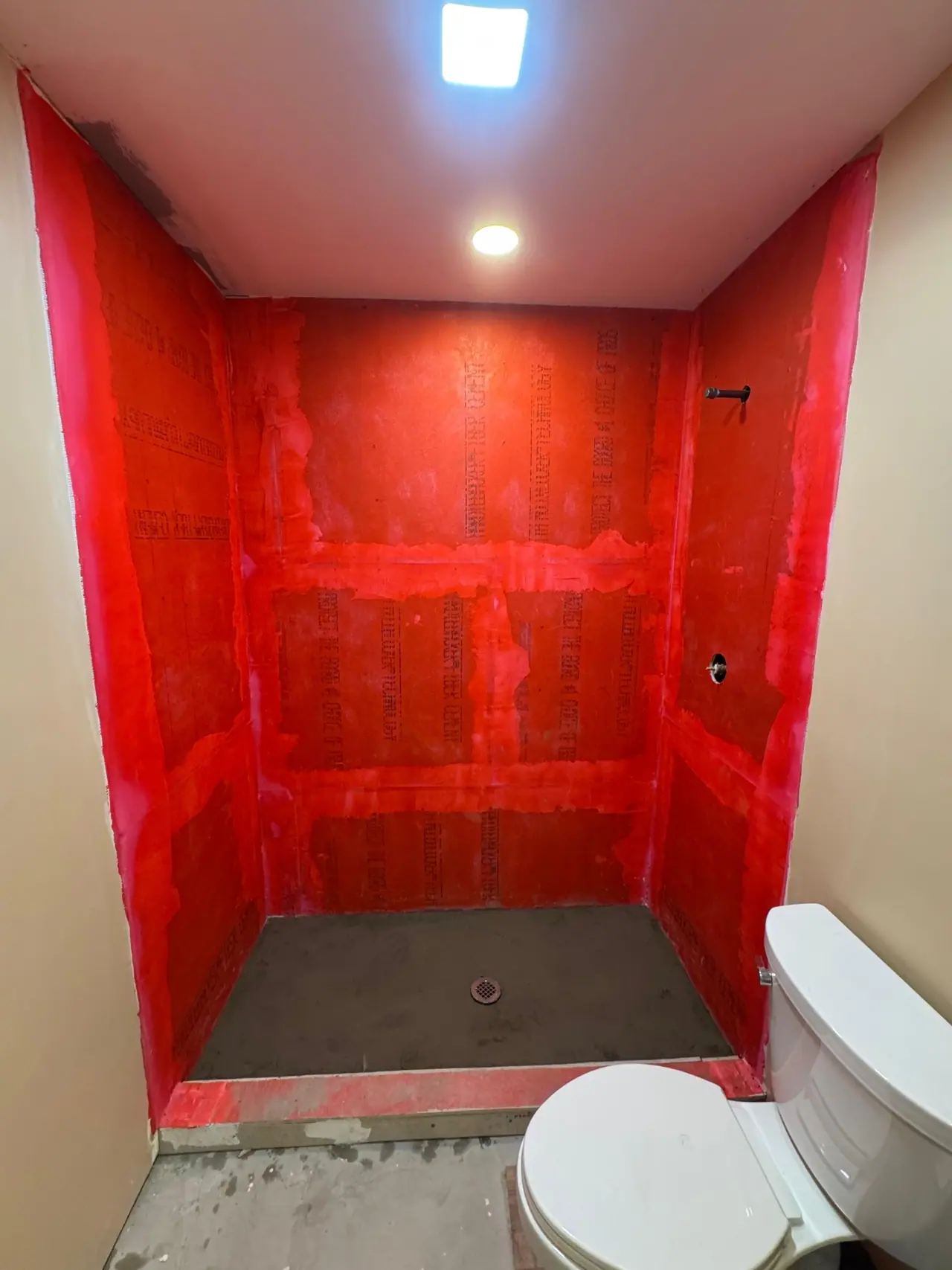 Full shower build — waterproof membrane, white herringbone subway walls, and a marble-look mosaic floor. — 1