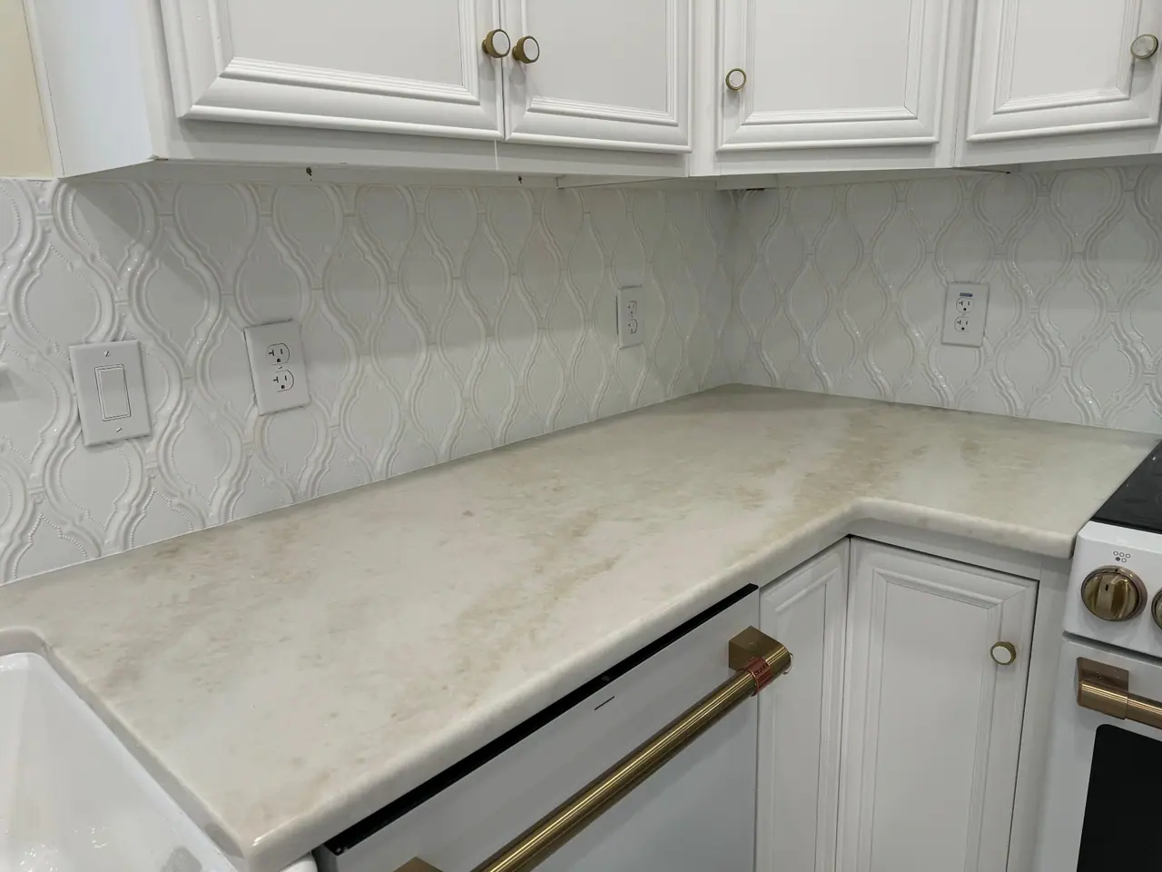 Arabesque-pattern ceramic backsplash with quartzite countertops and brushed brass hardware. — 2