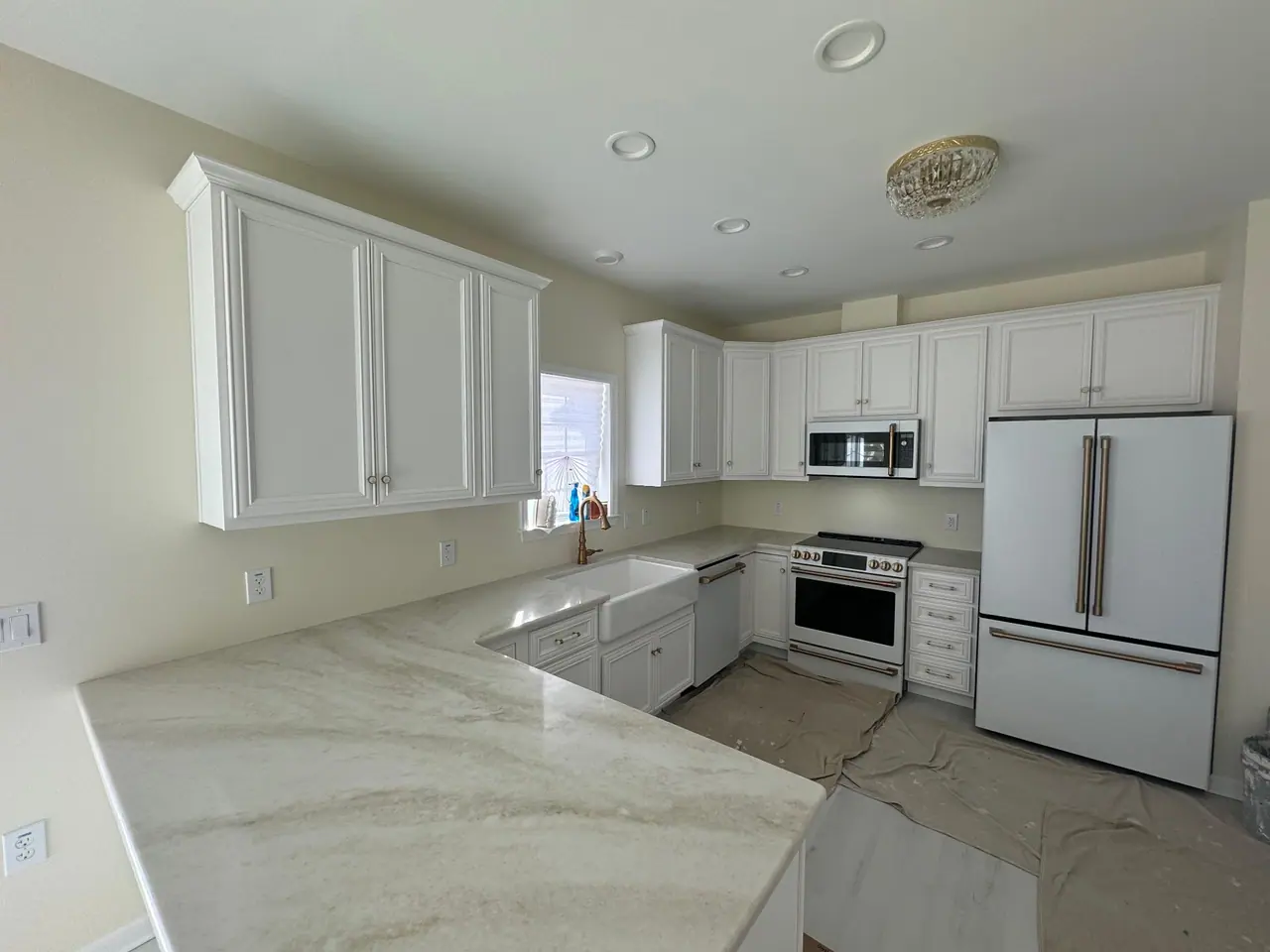 Arabesque-pattern ceramic backsplash with quartzite countertops and brushed brass hardware. — 3