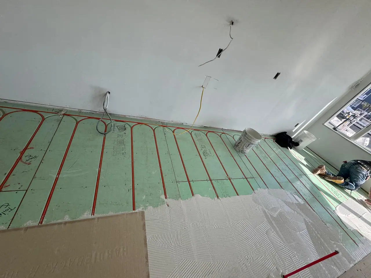 Full main floor build — radiant heating system, cement backer board prep, and large-format polished porcelain tile with waterfront views. — 2