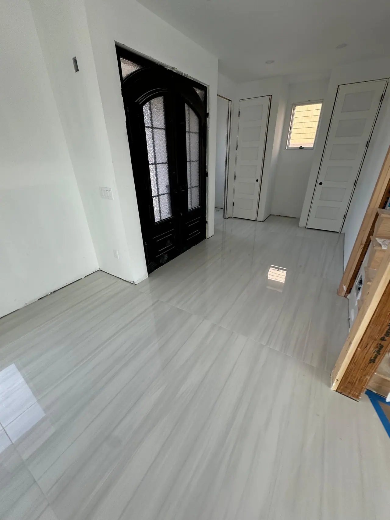 Full main floor build — radiant heating system, cement backer board prep, and large-format polished porcelain tile with waterfront views. — 5