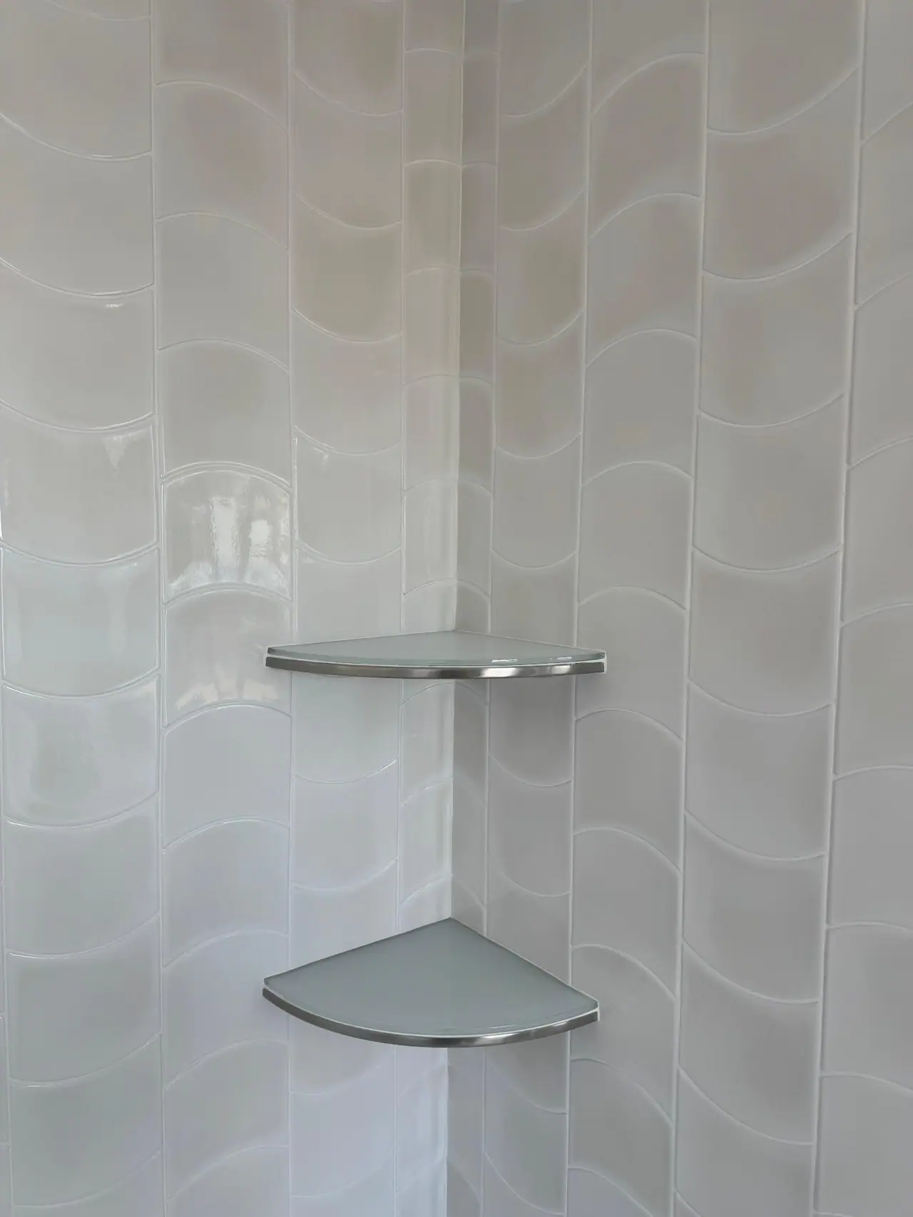Full bathroom tile installation with wave-pattern wall tile, glass corner shelves, and tub surround. — 3