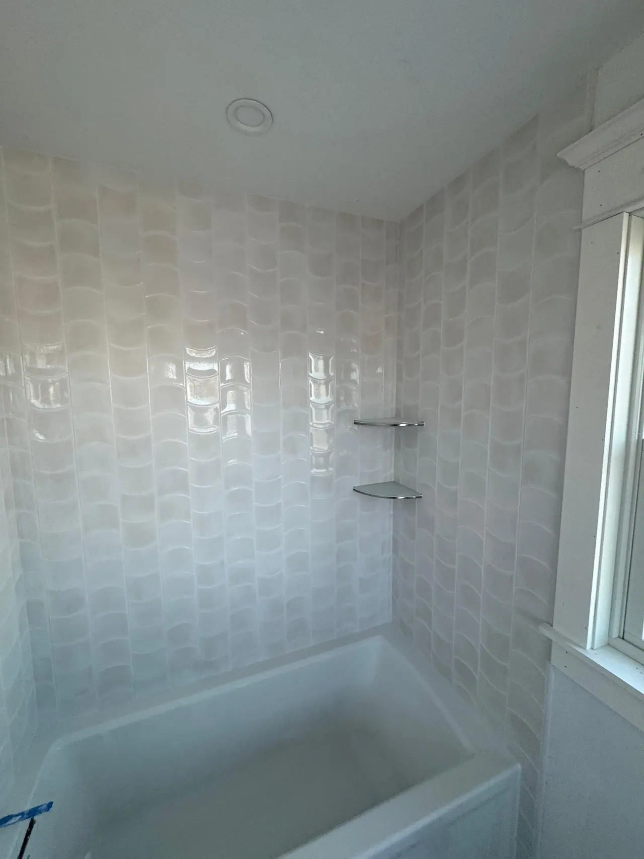 Full bathroom tile installation with wave-pattern wall tile, glass corner shelves, and tub surround. — 6