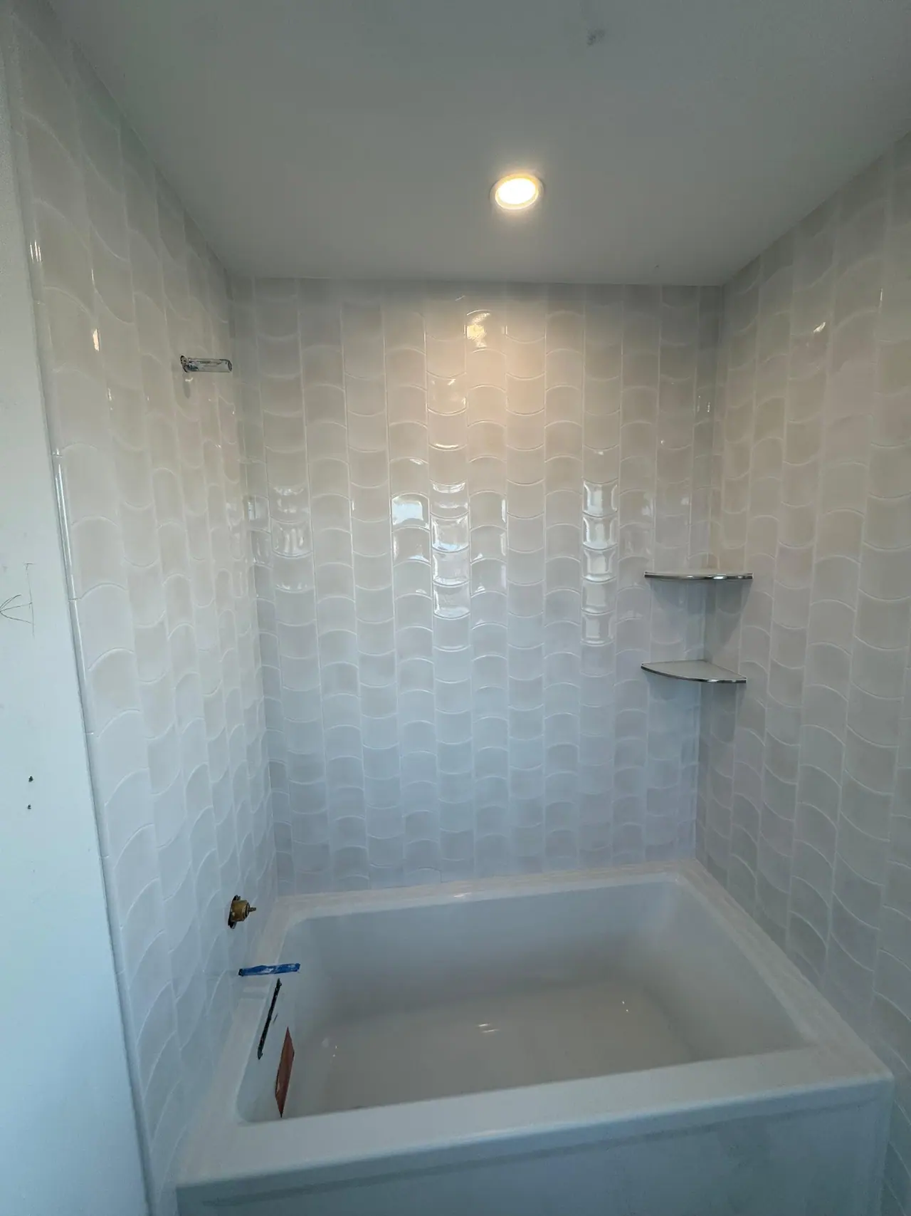Full bathroom tile installation with wave-pattern wall tile, glass corner shelves, and tub surround. — 7